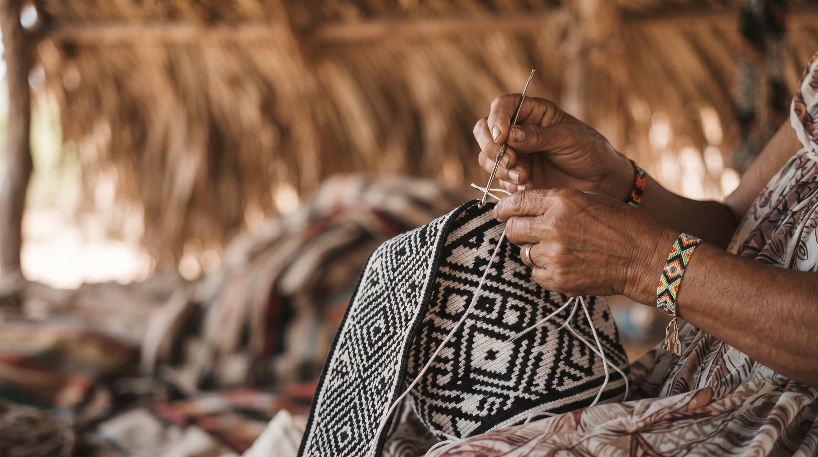Maestra artesana tejiendo mochila wayúu original de una sola hebra en La Guajira